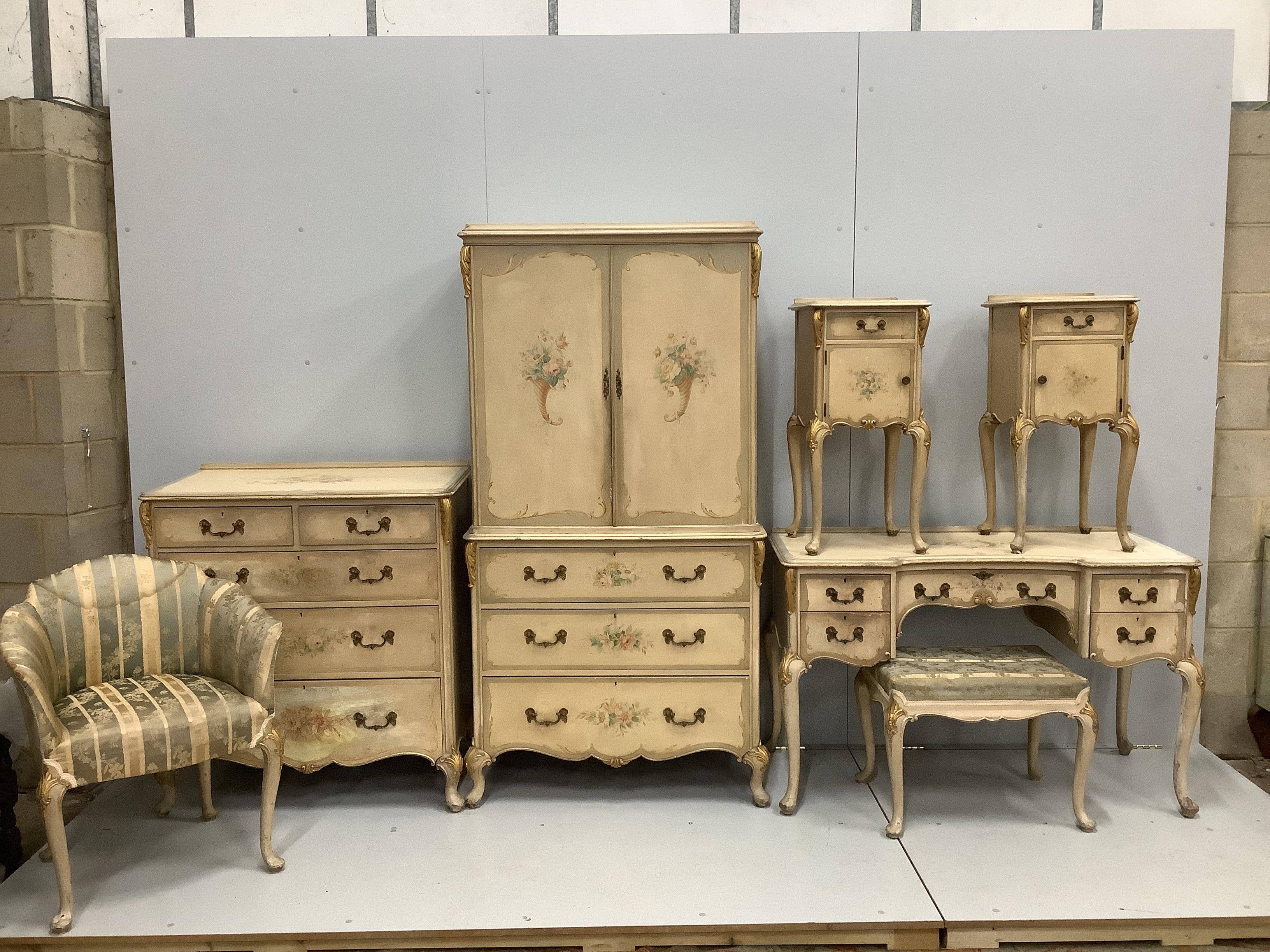 An 18th century style painted seven piece bedroom suite, comprising press cupboard, pair of bedside cabinets, kneehole dressing table, stool, chest of drawers and tub framed side chair